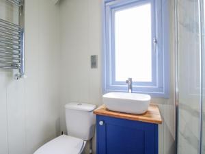 a bathroom with a toilet and a sink and a window at Skye in Ludlow