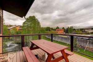 a wooden picnic table on a balcony with a view at 534 Sun River #8 in Fraser