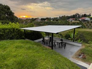 a pavilion with tables and chairs in a field at Finca cerca a Panaca - Birdhouse85 in Alcalá
