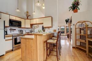 a kitchen with a large wooden island with bar stools at 534 Sun River #8 in Fraser