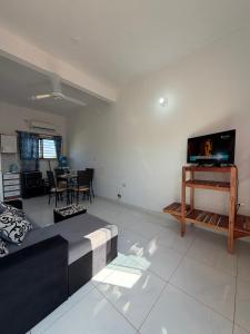 a living room with a couch and a tv at JG&A Home in Itauguá