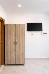 a wooden cabinet with a television on a wall at Kloen Sunset Villa in Sarandë