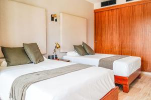 two beds in a hotel room next to each other at Jungle View Nest Selva Rooftop in Tulum