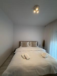 a bedroom with a large bed with two towels on it at Natalia Apart in Alba Iulia