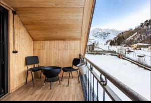 a balcony with chairs and a view of a snowy mountain at SetAura Kazbegi in Kazbegi