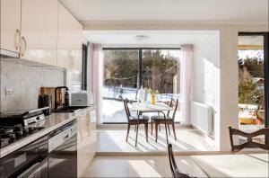 a kitchen with a table and chairs and a large window at SetAura Kazbegi in Kazbegi