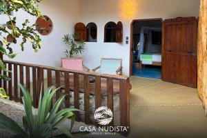 a porch of a house with a wooden fence at Casa Nudista - LGBT Hotel in Zipolite +123 photos