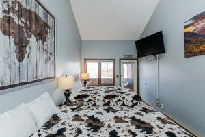 a bedroom with a bed and a flat screen tv at 645 Silvercreek Inn Room in Granby