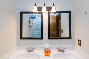 a bathroom with two sinks and two mirrors at 645 Silvercreek Inn Room in Granby