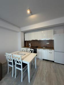 a kitchen with a table and chairs and a refrigerator at Natalia Apart in Alba Iulia