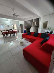 a living room with a red couch and a table at VILLA Moissuli maison entière confortable avec Starlink in Mtsamboro