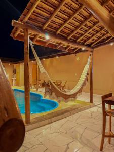 a patio with a hammock and a pool at SP Hospedagem Canoa Quebrada in Canoa Quebrada