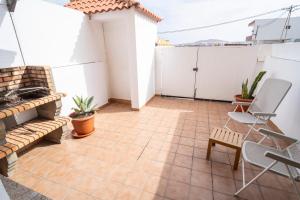 a small balcony with a table and chairs at Yesenia Vv Airport in El Matorral