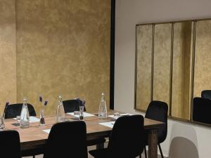 a conference room with a table with chairs and bottles at Kleos Hotel Milano Città Studi by Kleos Group Collection in Milan