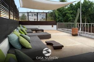a patio with pillows and a bench on a balcony at Casa Nudista - LGBT Hotel in Zipolite