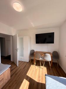 a room with a table and chairs and a television at Artland Quartier Quakenbrück in Quakenbrück +4 photos