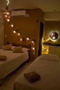 a bedroom with two beds with lights on the wall at SP Hospedagem Canoa Quebrada in Canoa Quebrada +11 photos