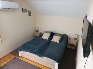 a bedroom with a large bed with two night stands at Liget Fruit Garden Family Apartman in Zalakaros
