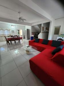 a living room with a red couch and a table at VILLA Moissuli maison entière confortable avec Starlink in Mtsamboro +24 photos