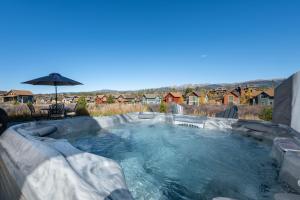 a hot tub in a backyard with an umbrella at 74 Alder Brook in Fraser