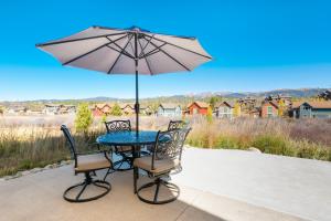 a table with two chairs and an umbrella at 74 Alder Brook in Fraser +28 photos