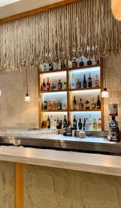 a bar at a restaurant with bottles on shelves at Coral Boutique Hotel in Vlorë