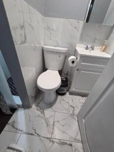 a white bathroom with a toilet and a sink at Queen Private room with private bathroom in Irvington