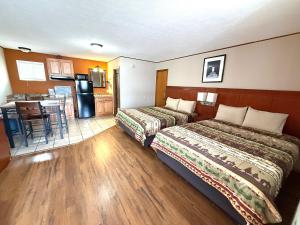 a hotel room with two beds and a kitchen at Hunter's Friend Resort near Table Rock Lake in Branson