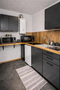 a kitchen with stainless steel appliances and a sink at Beau duplex lumineux avec balcon in Chalon-sur-Saône
