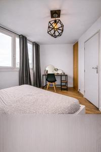 a bedroom with a bed and a desk with a chair at Beau duplex lumineux avec balcon in Chalon-sur-Saône