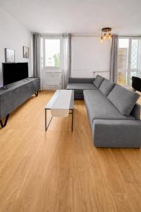 a living room with a couch and a table at Beau duplex lumineux avec balcon in Chalon-sur-Saône