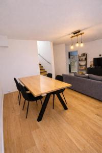 a wooden table and chairs in a living room at Beau duplex lumineux avec balcon in Chalon-sur-Saône +3 photos