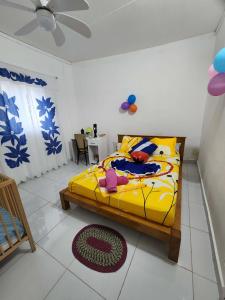 a bedroom with a yellow bed and a table at VILLA Moissuli maison entière confortable avec Starlink in Mtsamboro
