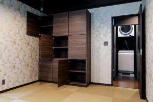a walk in closet with wooden cabinets and a appliance at 龍宿 Noboru Yado in Kagoshima