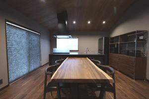 a dining room with a wooden table and a kitchen at 龍宿 Noboru Yado in Kagoshima +34 photos