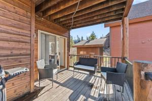 a wooden deck with chairs and a couch on it at 820 Badger Ln in Fraser