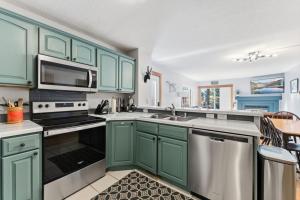 a kitchen with green cabinets and a sink at 820 Badger Ln in Fraser