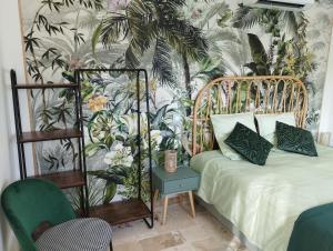 a bedroom with a bed with a tropical wallpaper at Chambre 2 pers SPA Piscine in Grospierres +27 photos