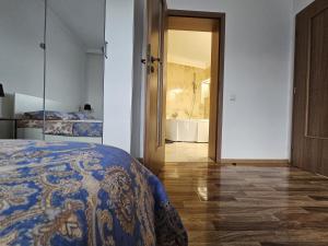 a bedroom with a bed and a bathroom with a tub at Dante Residence in Alba Iulia
