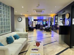 a living room with a white couch and a clock at Trakya City Hotel in Edirne