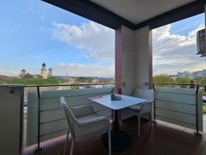 a table and chairs on a balcony with a view at Dante Residence in Alba Iulia