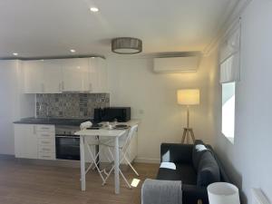 a kitchen with a couch and a table in a room at Modern Studio with Private Patio near Cascais & Sintra in Alcabideche