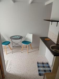 a small kitchen with two chairs and a table at Le studio des pins in Plouézec