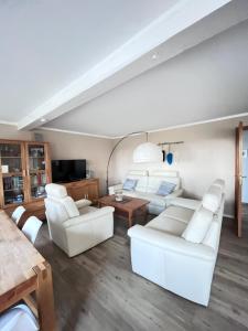 a living room with white couches and a table at Fewo Sort Sol - Auszeit in perfekter Alleinlage in Aventoft