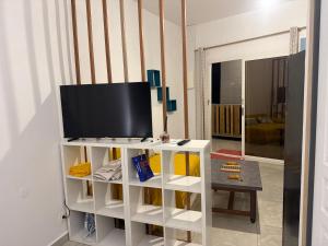 a living room with a tv on a white entertainment center at Le manga in Chiconi