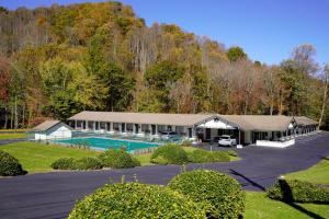 a building with a pool and a parking lot at Scottish Inn Maggie Valley in Maggie Valley