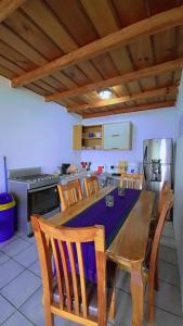 a kitchen with a wooden table with chairs and a kitchen with at Hotel Victoria Atitlan in San Pedro La Laguna