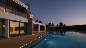 a house with a swimming pool next to a house at Sani Chateau in Sani Beach