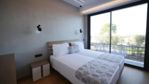 a bedroom with a large bed and a large window at Sani Chateau in Sani Beach