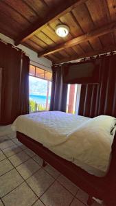 a bedroom with a bed with a view of the ocean at Hotel Victoria Atitlan in San Pedro La Laguna